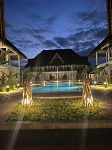 un complexe avec une piscine ouverte la nuit dans l'établissement Rafiki Jua Resort, à Watamu