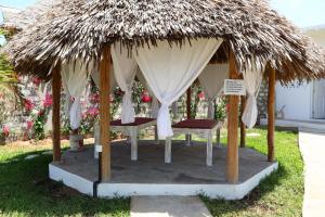 a gazebo with two beds and a thatch roof at Rafiki Jua Resort in Watamu