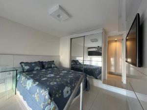 1 dormitorio con cama y espejo grande en Lindo Loft Beira-Mar na Vitória en Salvador