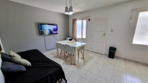 ein Wohnzimmer mit einem Sofa, einem Tisch und einem TV in der Unterkunft Casa familiar de 2 dormitorios in Neuquén