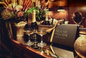 a table with two glasses of wine and a house of goods at House of Gods Glasgow in Glasgow