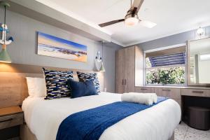 1 dormitorio con 1 cama grande con detalles en azul en Chakas Cove 44, en Ballito