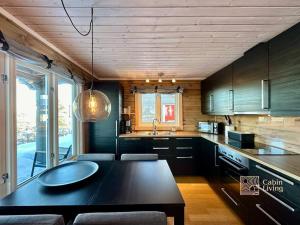 - une cuisine avec une table noire et un évier dans l'établissement Cozy cabin with incredible views and sauna, à Lampeland
