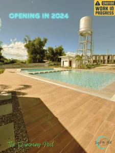 a swimming pool with a water tower in the background at Lovely Homes at Casa Mira Bacolod in Bacolod