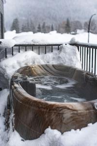 wanna z hydromasażem pokryta śniegiem na dziedzińcu w obiekcie Powder Village Retreat by Revelstoke Vacations w mieście Revelstoke