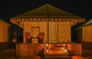 a stage with two chairs and a table with lights at Hotel Kesar Dunes in Jaisalmer