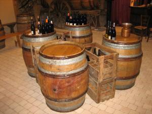 Une bande de tonneaux de vin alignés dans une pièce dans l'établissement La maison du vigneron, à Ternand