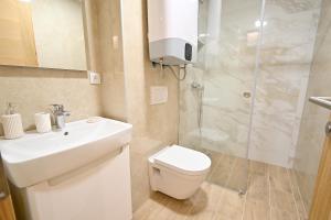 a bathroom with a toilet and a sink and a shower at Grand Apartment Lučić in Jahorina