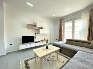 a white living room with a couch and a table at Vlora Apartment in Vlorë