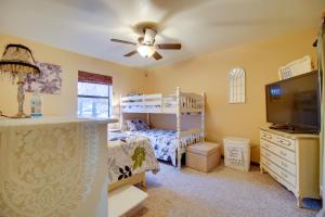 a bedroom with a bunk bed and a flat screen tv at Tahlequah Duplex with Screened-in Porch and Fire Pit! in Tahlequah