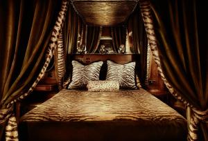 una camera da letto con letto a baldacchino con cuscini di House of Gods Glasgow a Glasgow