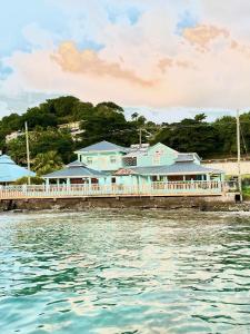 a building on a pier next to the water at Basil At Villa in Arnos Vale