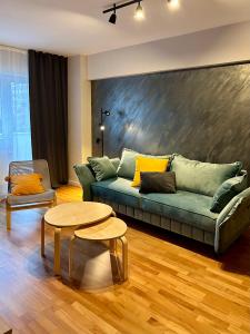 a living room with a green couch and a table at Blue Mountain Residence in Braşov +12 photos