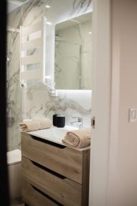 ein Badezimmer mit Waschbecken und Spiegel in der Unterkunft Suits recién reformadas Marqués de Vadillo in Madrid