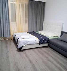 a bedroom with a bed and a couch at Apartament spatios - zona UTA in Arad