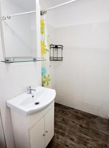 a bathroom with a white sink and a mirror at Apartament spatios - zona UTA in Arad