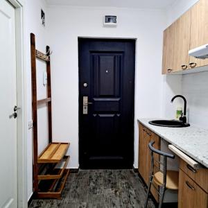 a black door in a kitchen with a counter at Apartament spatios - zona UTA in Arad