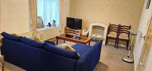 a living room with a blue couch and a tv at 2Bedroom Home away from Home in Manchester