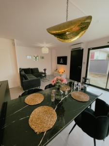 uma sala de estar com uma mesa verde e cadeiras em Maison moderne proche CDG, Paris em Tremblay En France