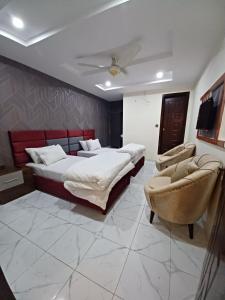 um quarto com 2 camas, um sofá e um tecto em Executive Residency em Multan