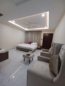 uma sala de estar com uma cama, um sofá e uma mesa em Executive Residency em Multan