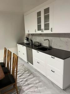 a kitchen with white cabinets and a black counter top at Härligt stort boende i perfekt läge in Borås