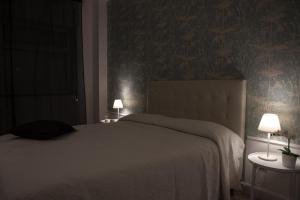 a bedroom with a large bed with two tables and two lamps at Acqua Holiday House in Taranto