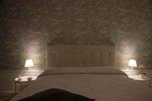 a bedroom with a large bed with two lamps at Acqua Holiday House in Taranto