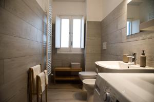 La salle de bains est pourvue d'un lavabo, de toilettes et d'une fenêtre. dans l'établissement Acqua Holiday House, à Tarente