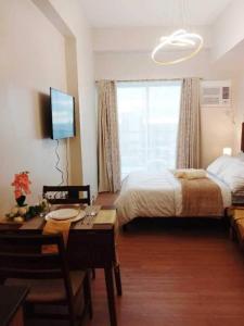 a bedroom with a bed and a table and a desk sidx sidx sidx at The Loop North Tower in Cagayan de Oro