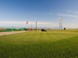 um campo de golfe com um carro num campo verde em Sakura Homes Torre de Hércules 7 plazas em La Coruña