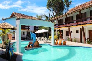 a pool at a resort with a dolphin statue at Casa Blanca Park Hotel in Porto Seguro