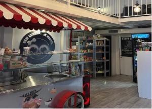 a restaurant with a counter with a red and white canopy at New Generation Hostel Milan Center in Milan