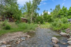 a stream in front of a cabin with a house at HTR Durango in Durango