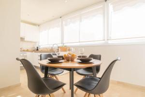 una cucina con tavolo, sedie e bicchieri da vino di Apartamento Marbelsun ll a Marbella