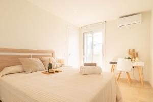 a white bedroom with a large bed and a desk at Apartamento Marbelsun ll in Marbella