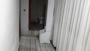 a hallway with a toilet in a room with curtains at M Pension in Addis Ababa