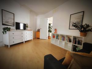 een woonkamer met een witte dressoir en een tv bij Nueve Pies Surf house in Las Palmas de Gran Canaria