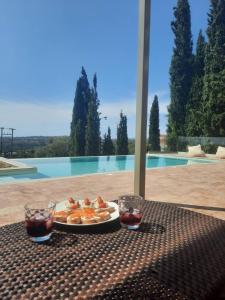 un tavolo con un piatto di cibo e due bicchieri di soda di ReLux Villa a Cefalonia