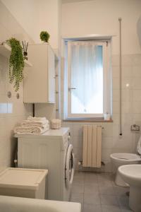 a white bathroom with a sink and a washing machine at Discover Sustainable Bliss: 2-BR Apartment in Rome in Rome