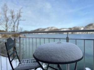 a snow covered chair sitting on top of a balcony at Brunnwirt ESSEN & WOHNEN in Fuschl am See