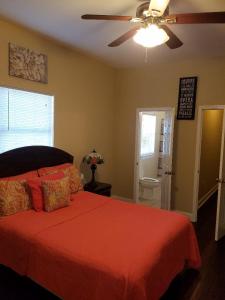 a bedroom with a red bed with a ceiling fan at Troy's Place in New Orleans