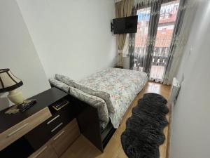 a small bedroom with a bed and a window at Marina Apartment in Bansko