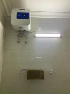 a toilet in a bathroom with a towel dispenser at Zebra House Stonetown in Ngambo
