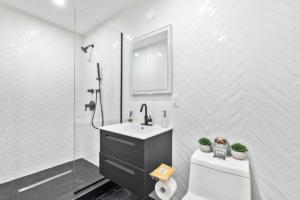 ein Bad mit einem Waschbecken, einer Dusche und einem WC in der Unterkunft Luxe Studio with Charming Juliet Balcony in New York