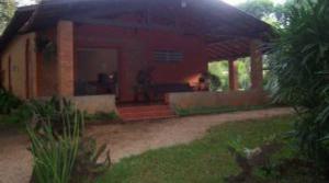 a red house with a dog in the front yard at Chácara Irmandade in Ribeirão Preto