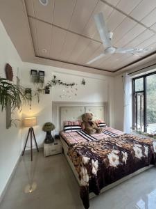 un osito de peluche sentado en una cama en un dormitorio en Suri Homestay - Best Homestay In Dalhousie, en Banikhet