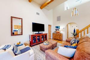 Una sala de estar con sofás y un televisor de pantalla plana. en Hideaway on Habitat, en Cave Creek