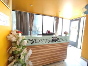 a kitchen with windows and a counter with flowers at Hotel Vraj in Rājpīpla