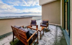 two chairs and a table on a balcony with snow at WiLUKA Penthouse mit großer Dachterasse nachhaltig eingerichtet Netflix in Limburg an der Lahn